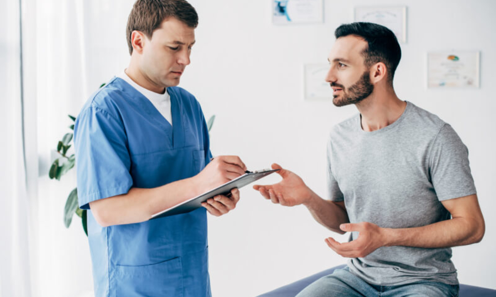 Patient sitting on couch and doctor writing