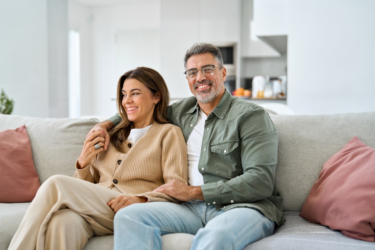 Couple sharing a warm moment on the couch, illustrating the TRT libido timeline and how sex drive changes over time